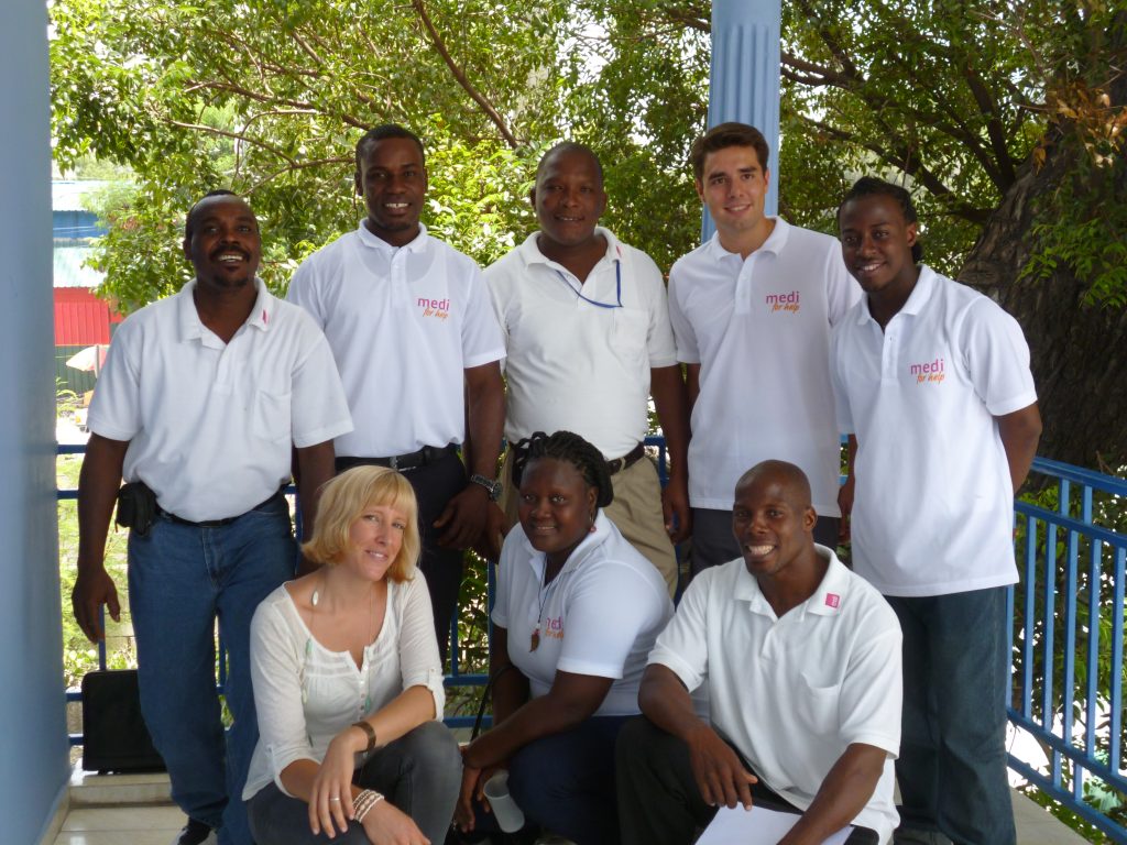 Gruppenbild von Cornelia Koehler mit einem medi for help Freiwilligen und mehreren Haitianern