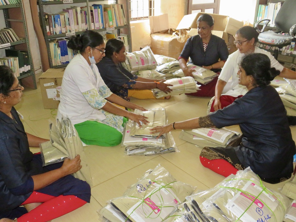 Volunteers sit together and practise putting on and taking off the circaid compression systems independently.