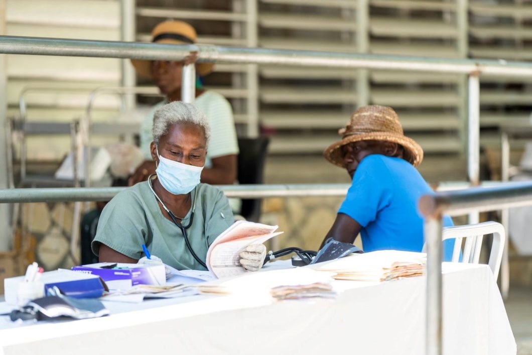 Haitianer wartet auf Behandlung während Frau Dokumente ausfüllt