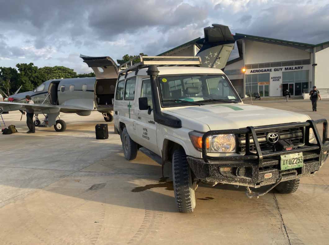 Auto und Flugzeug auf Rollfeld in Haiti